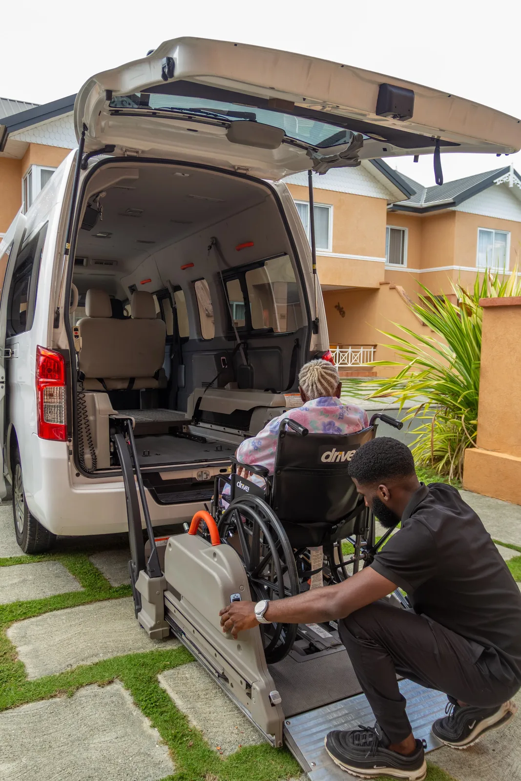 Wellness Express team member preparing the rear wheelchair lift on the accessible Nissan NV350