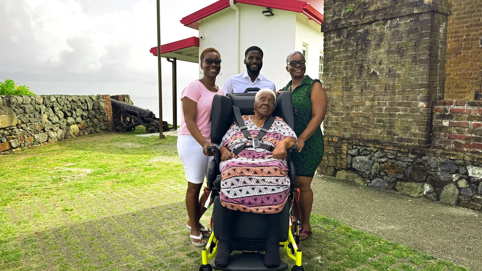 Client seated in the Broda Traversa Transport Wheelchair with family and Wellness Express staff in Tobago